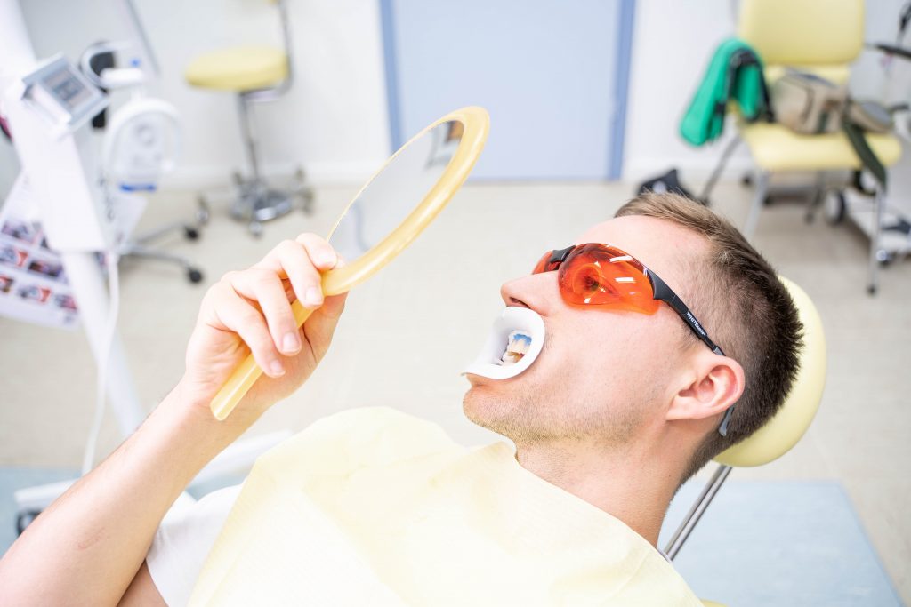 Patient schaut sich das Zwischenergebnis der Zahnaufhellung an