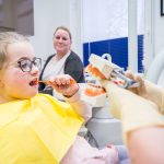 Junge Patienten bekommt das Zähneputzen erklärt