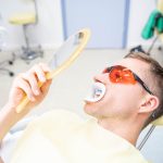 Patient schaut sich das Zwischenergebnis der Zahnaufhellung an
